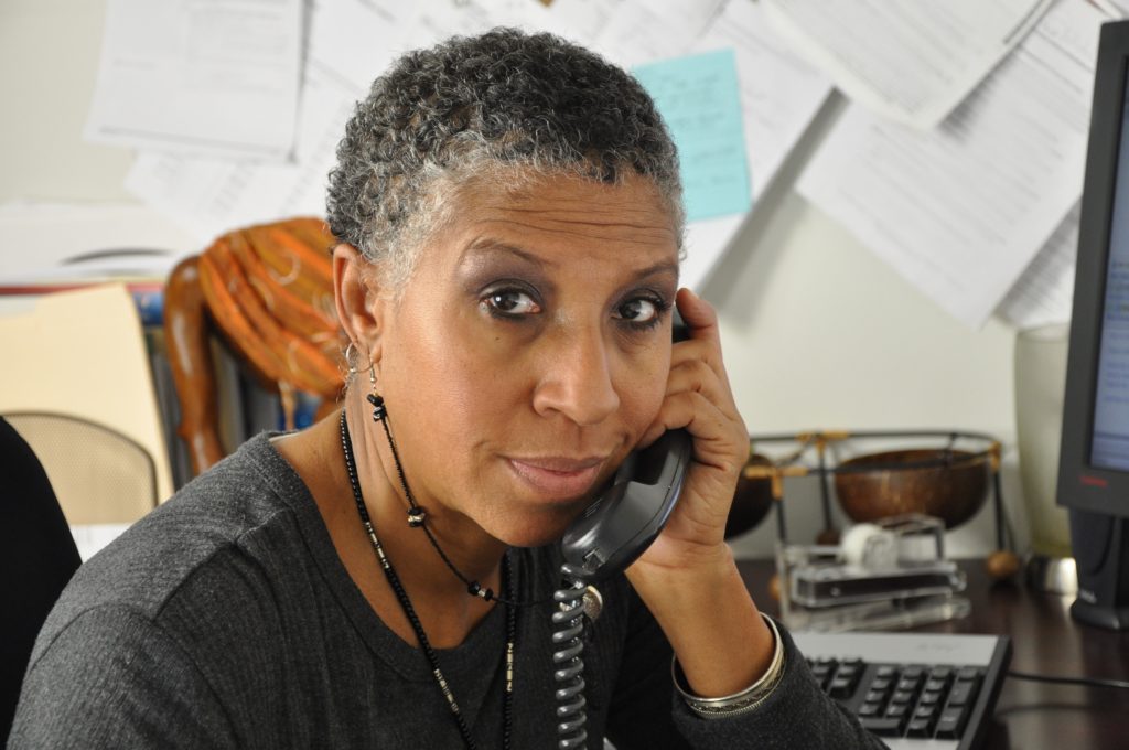 African American professional woman looking at you while on the telephone
